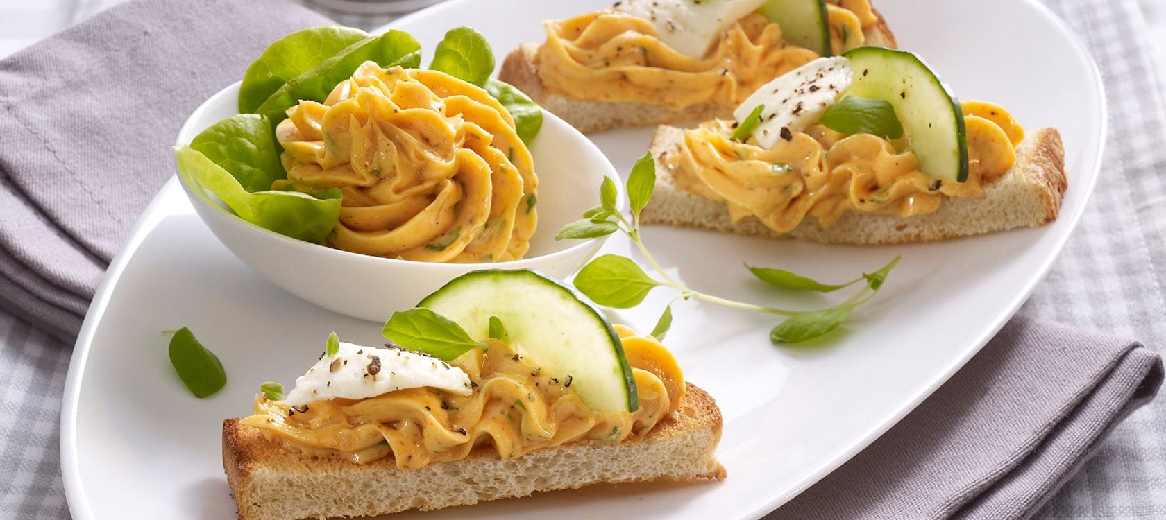 Cracker mit Gemüse-Tomaten-Aufstrich auf Salat