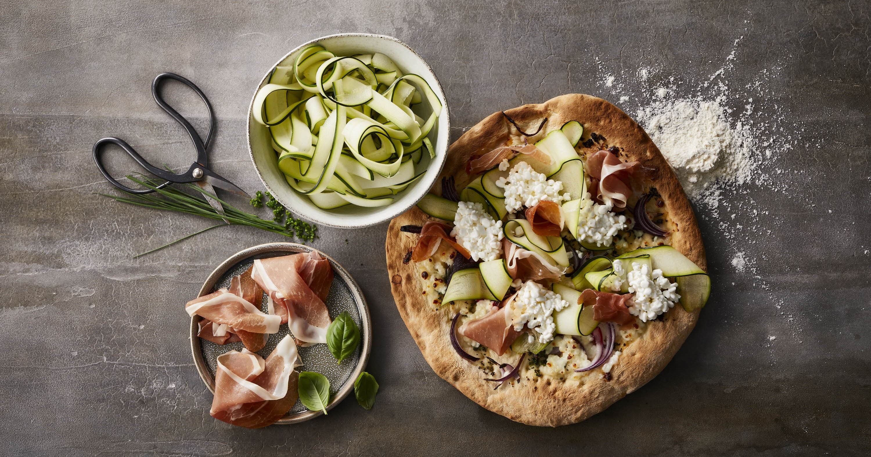 Pizza med hytteost, parmaskinke og basilikum