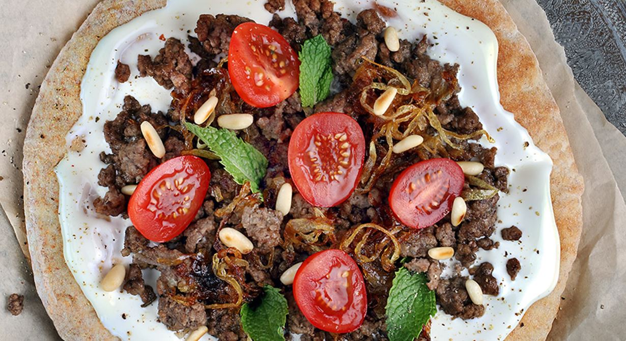 Arabic bread with cream cheese, minced meat, caramelized onions, tomatoes and mint