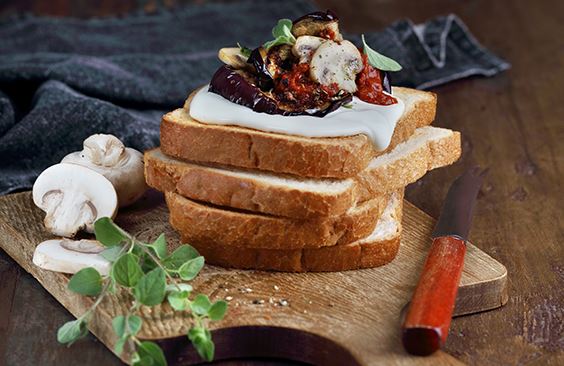 Toasts with cream cheese, grilled eggplants in tomato sauce and mushrooms, with oregano