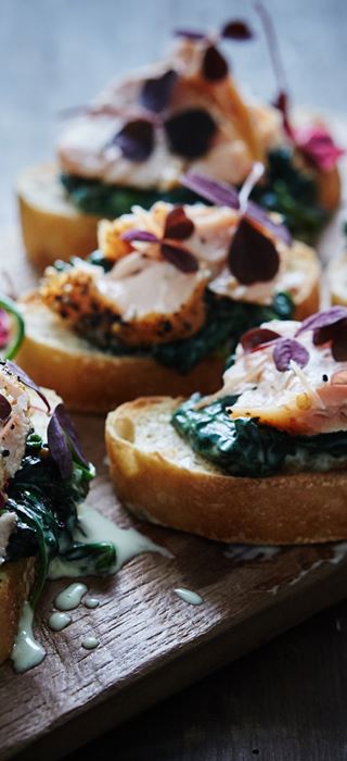 Crostini with spinach in white sauce and hot-smoked salmon