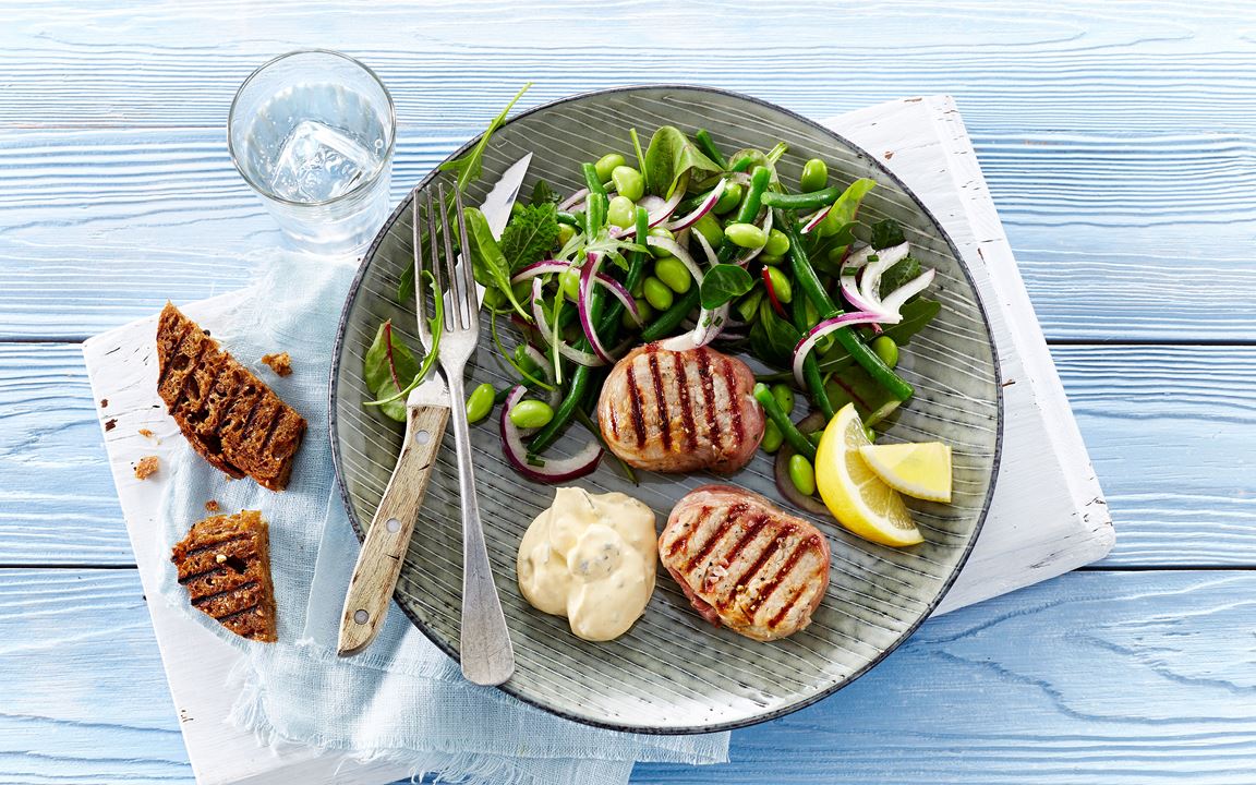 Grilled tenderloin medallions with prosciutto and edamame and bean salad