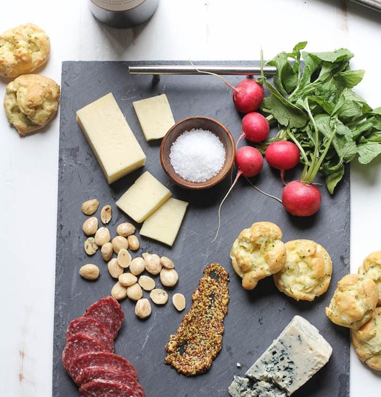 Spring cheese board with herb and pickled ramp gougeres