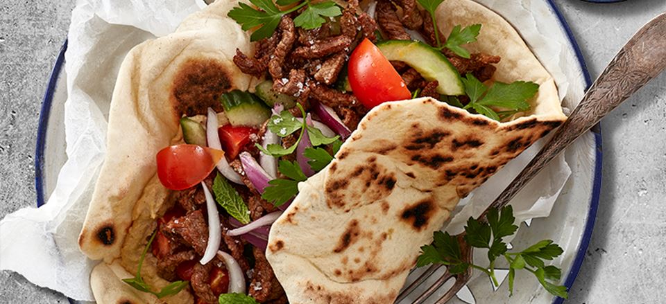Kebab med fladbrød, hummus, grillet peberfrugtsdressing og friske grøntsager-image