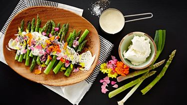 Green asparagus with cream cheese, flowers and charred spring onions