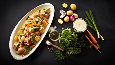 Warm potato salad with vegetables and herbs