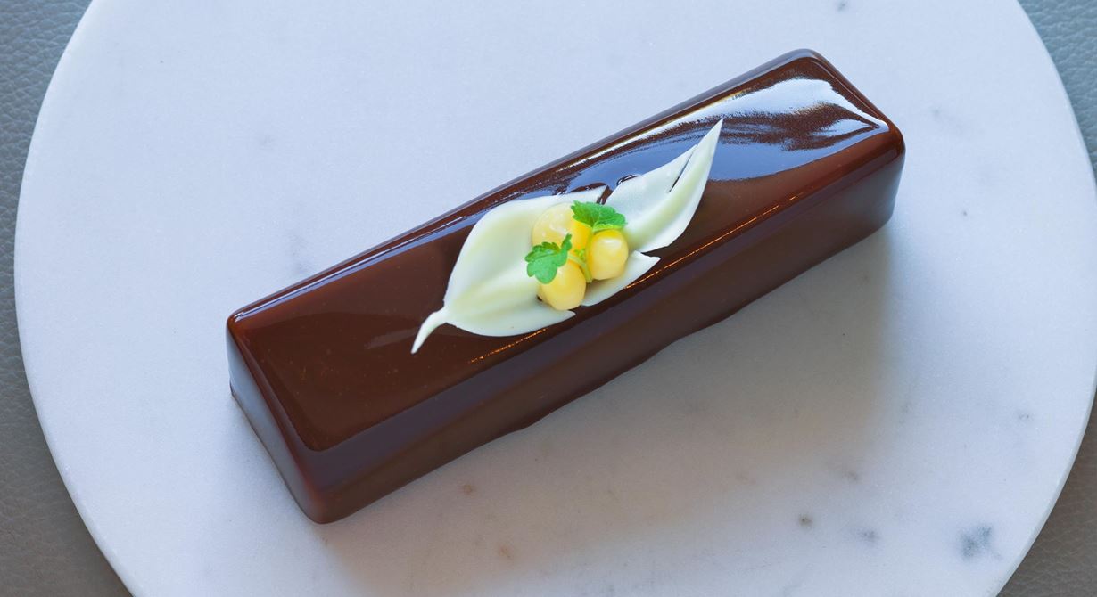 En dröm för alla chokladälskare. Krämig, silkeslen chokladmousse med syrlig calamansicrème, krisp från karamelliserade kakaonibs och seg browniebotten.
Högsta glansighet och syrlig ton i eftersmaken.