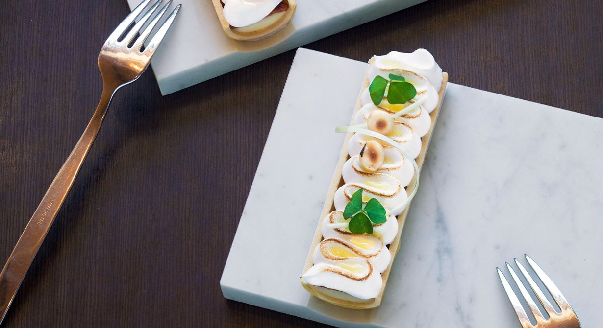 En klassiker i ny design. I perfekta mördegsskal ligger en smakrik citroncrème med krispig nougat inbäddad i italiensk maräng. Droppar av syrlig yuzugelé och rostade
hasselnötter blir som smycken ovanpå.