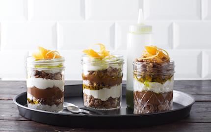 En ljuvlig dessert och ett smakfullt blickfång som säljer. Varva färskostkräm med kolasås och dinkelcrunch i glas. Citronverbenaoljan får sin härliga färg av babyspenat.