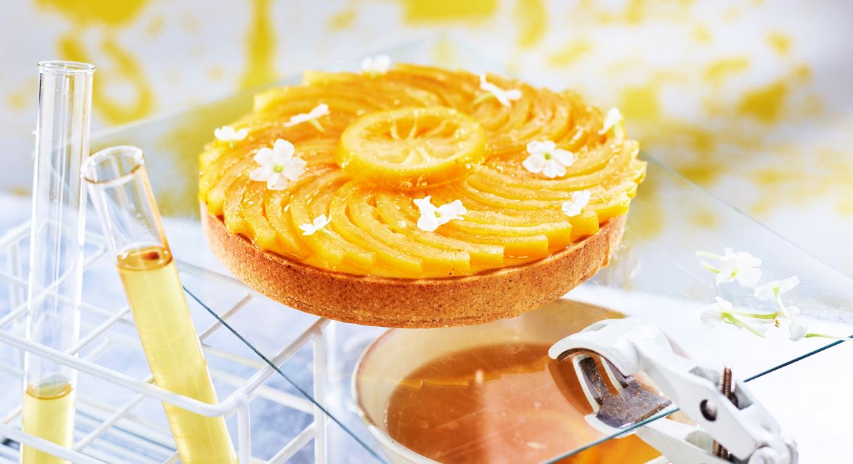 Citrustarten med en botten på dinkel fylls med len och syrlig sudachicurd. På curden läggs skivor av inkokta citroner som fått en blommig touch av fläder.
