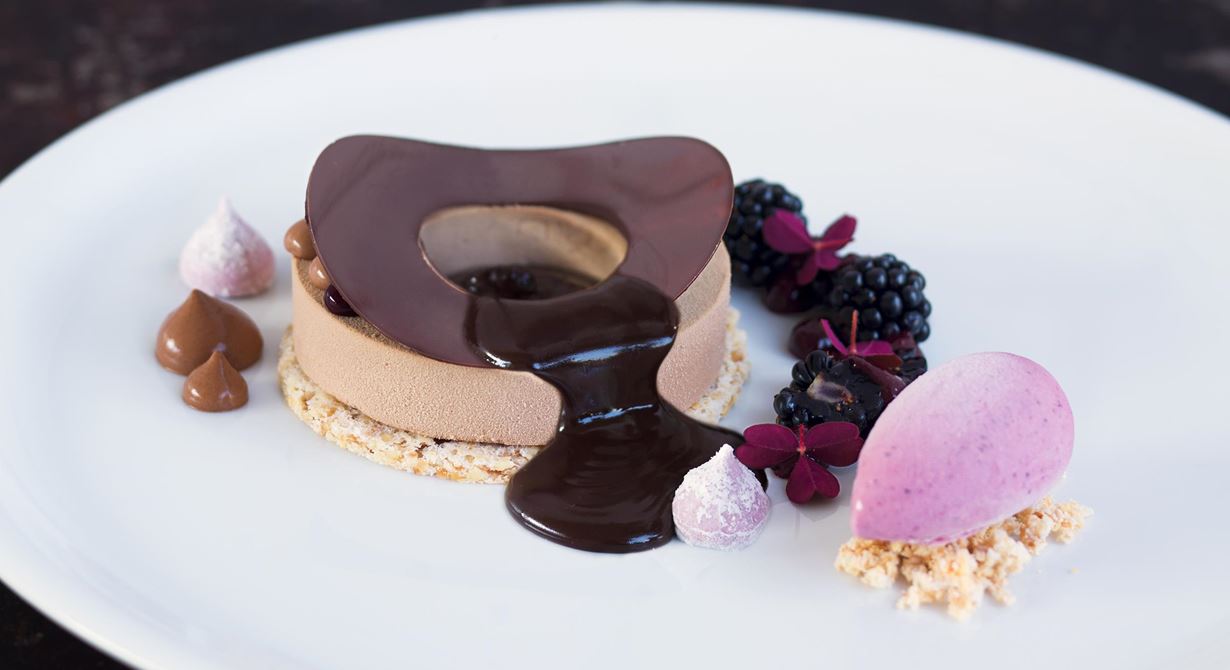 En hyllning till Tore Wretman och en variant på Gâteau Riche Gala. Vaniljglassen är utbytt mot björnbärsglass som här ligger bredvid bakelsen med chokladbavaroise.
Överraska med varm chokladsås med kaffesmak.