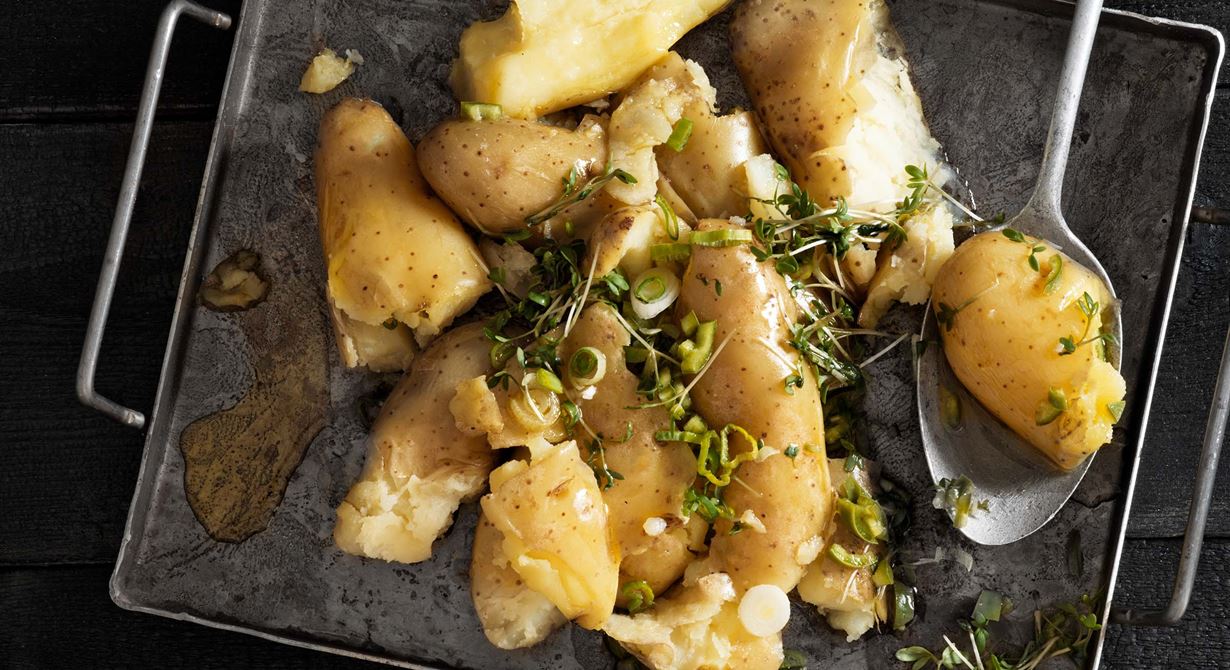 Krossa kokt potatis och rosta den härligt frasig i ugn. Har du kokt potatis över så går det också bra. Toppa med en het, syrlig citronvinägrett med grön chili som ger extra smakskjuts och fräschör. 