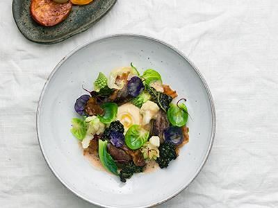 Rustik och elegant på samma gång. Långkokt, trådigt lammlägg med krämig blomkål, krispigt kål och smakrikt lammbacon. Bakade tomater ger balanserad sötma.