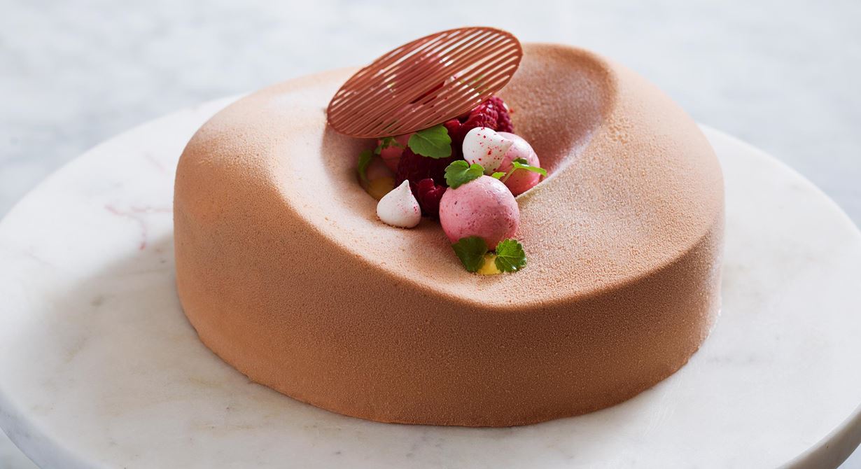En elegant tårta med fantastiska smaker. Karamelliserad, luftig mjölkchokladmousse varvas med len hallonpannacotta, seg browniebotten och
syrlig passionsfruktcrème. Allt toppat med hallon och sötsyrliga yoghurtmaränger.