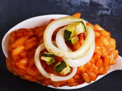 Risotton färgas röd med paprikajuice och toppas med nystekt squid och tärnad zucchini. Perfekt att servera som förrätt eller som ett snack eller amuse bouche på en sked.