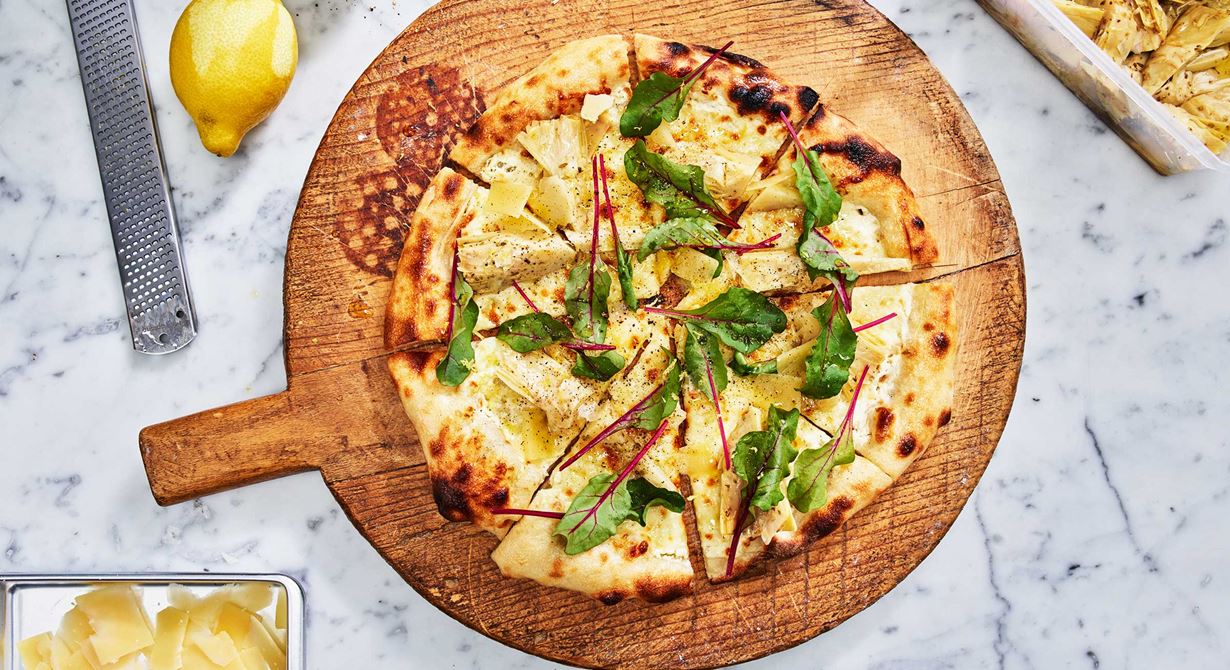 En vegetarisk pizza med schmand som passar den ljusa tiden på året! Kronärtskocka med örter, späda mangoldblad och citronskal blir tillsammans en fräsch pizzatopping.