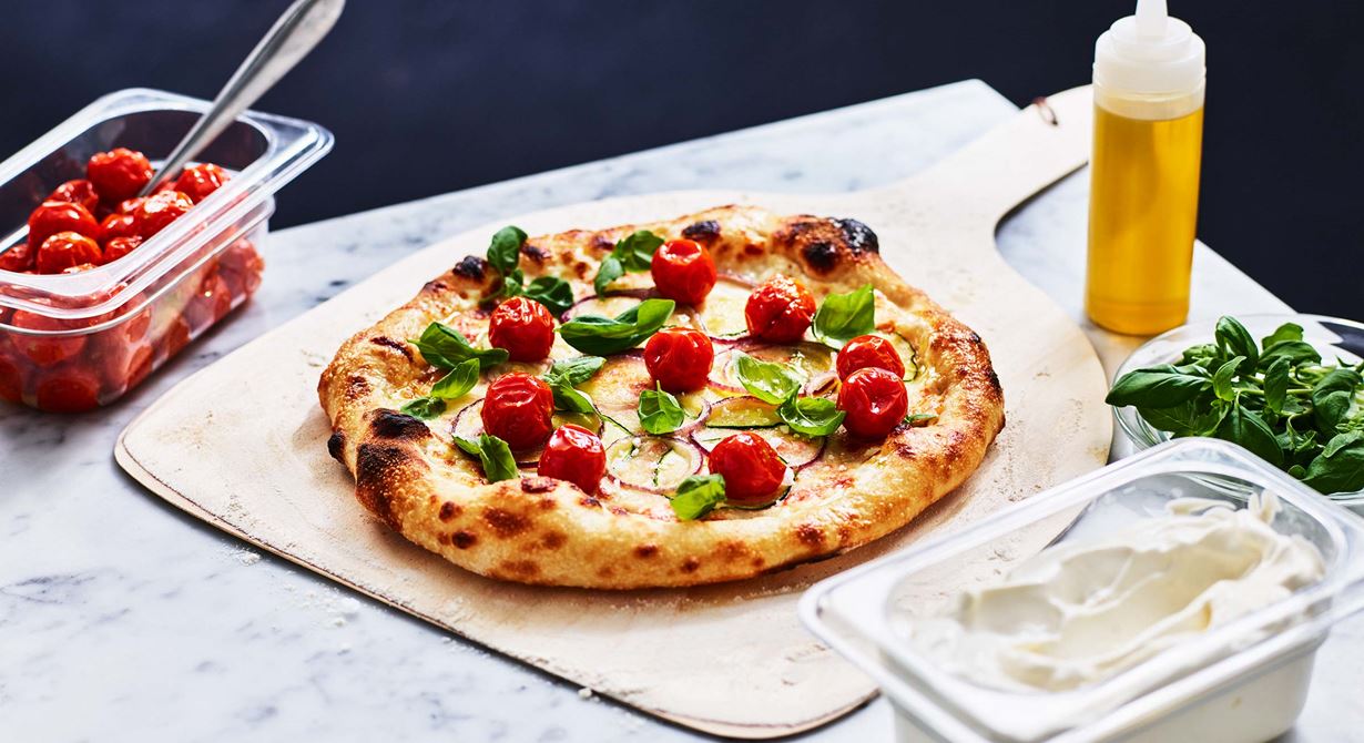 En vegetarisk pizza som passar på menyn året om. Både schmand och tomatsås är basen på den här pizzan. Den toppas med tunna skivor zucchini och rödlök innan den bakas. Vid servering toppas pizzan med långbakade små smakrika tomater och späda basilikablad.