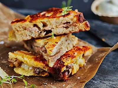 Porchetta är en italiensk rätt där fläskkött fylls med vitlök, fänkål och rosmarin för att sedan grillas eller bakas långsamt tills det nästan faller sönder. När det svalnat kan det skivas tunt och bli en riktigt god fyllning i en frasig toast med ost som sällskap. Servera gärna tillbehör till som en senapsdipp på färskost samt frisk, krispig surkål.
