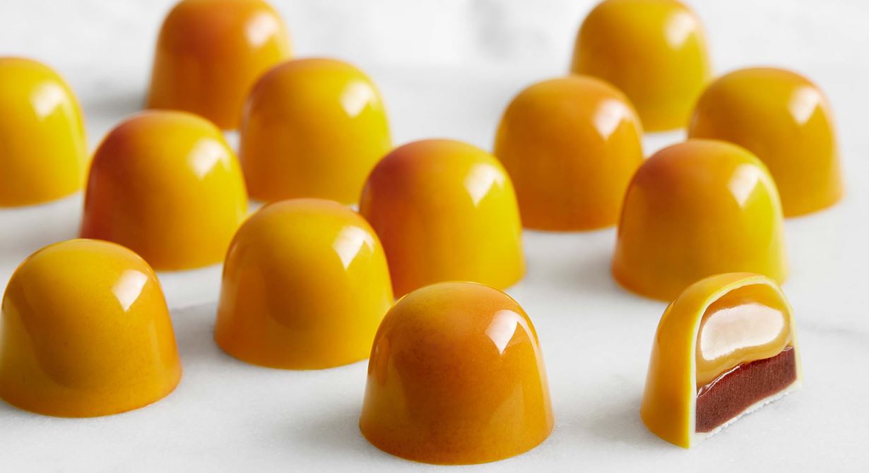 De gyllene, glansiga pralinerna fyllda med kanelganache och mandarinkaramell är helt oemotståndliga. De är fint sprejade så att färgen skiftar och den ena sidan blir något mörkare. Konjaken i karamellen bara anas och ger en djupare smak ihop med kanelens mjuka ton.