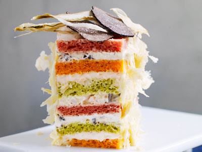 Den här lyxiga smörgåstårtan med naturligt färgade grönsaksbröd och eleganta fyllningar i olika lager kan serveras som en liten bakelse. De krämiga fyllningarna är smaksatta med varmrökt lax, räkor och champinjoner samt brieost och oliver.