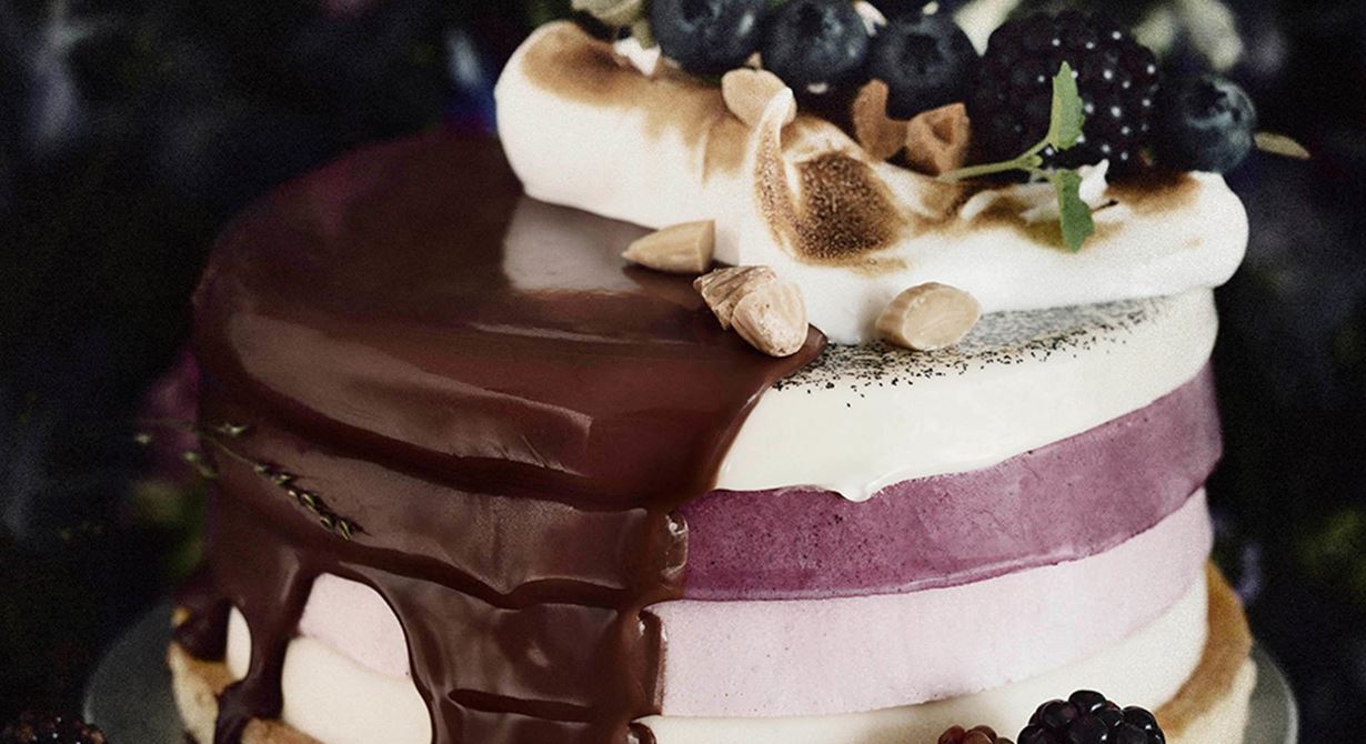 Blåbärsmousse med vaniljpannacotta och björnbärsmousse kröns av saltrostad mandel, italiensk maräng och en mjölkchokladglaze.