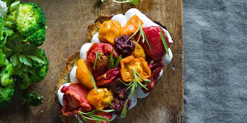 En försvenskad bruschetta med små gravade tomater i olika färger, som torkas i ugn för att få ut vattnet och koncentrera smakerna. Brödet toppas först med färskost smaksatt med kyndel istället för basilika.