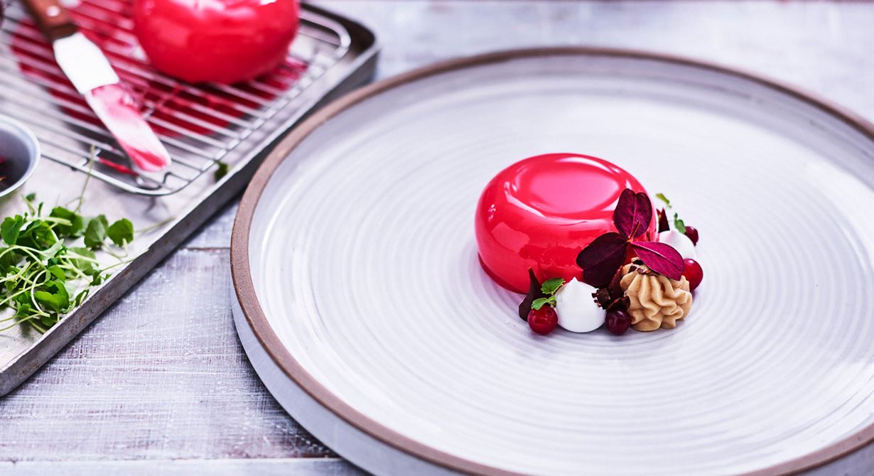 En dessert som passar vid större sällskap och event. Tranbärsbakelsen tas ur frysen någon timme före servering och glaseras direkt. Dekorera med övriga komponenter och ställ i kyl fram till servering.